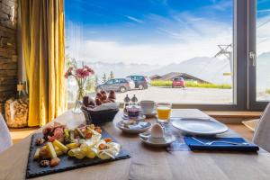 a table with a plate of food and a window at Rinderberg Lodge in Zweisimmen