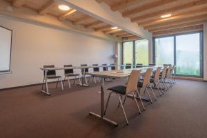 a conference room with a long table and chairs at Rinderberg Lodge in Zweisimmen