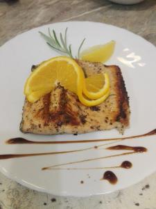 un pezzo di pesce con un limone su un piatto di Captain Niko Apartments a Burgas Altre 52 foto
