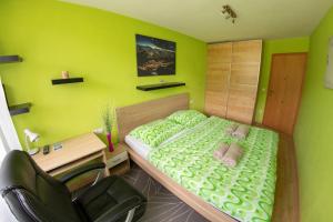 Habitación verde con cama y escritorio. en Powderia Family & Freelance Apartment in the center of Ski Amadé, en Altenmarkt im Pongau