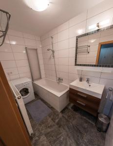 a bathroom with a tub and a sink and a toilet and a bath tub at Powderia Family & Freelance Apartment in the center of Ski Amadé in Altenmarkt im Pongau