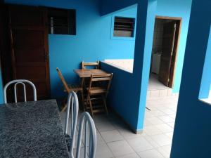 a kitchen with a blue wall and a table and chairs at Hostel Villa Pomerânia in Pomerode