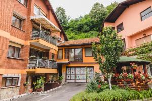 an image of a building with flowers in the courtyard at Rooms & Apartment GH Pasha in Tuzla