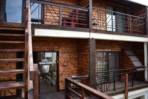 a wooden house with a balcony and a staircase at Vila Tudor Mamaia Nord in Mamaia Sat/Năvodari +7 photos