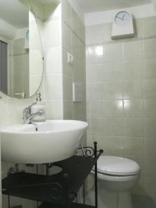 łazienka z umywalką, toaletą i lustrem w obiekcie La Dimora del Marinaio w Genui +28 zdjęć