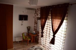 a room with a window with curtains and a table at Vila Tudor Mamaia Nord in Mamaia Nord