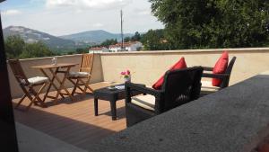 a patio with chairs and a table on a balcony at Apartamento Avenida in Ponte de Lima