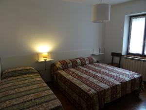 a hotel room with two beds and a window at Appartamento da Davide in Pieve Di Ledro