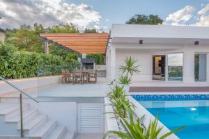 a villa with a swimming pool and a house at Luxury apartment Shelena in Mravince