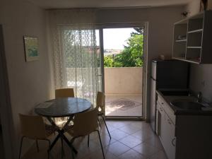 a kitchen with a table and chairs and a window at Apartments MiaMaja in Novalja