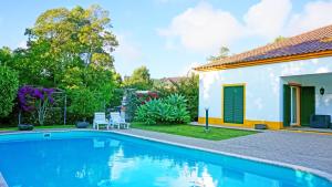 una casa con piscina al lado de un edificio en Quinta dos Aromas, en Lagoa