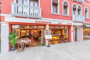restauracja ze stołami i krzesłami przed budynkiem w obiekcie New Reiter Hotel w Lido di Venezia