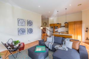 uma sala de estar com um sofá azul e uma cozinha em Alfies on Albert Daylesford em Daylesford