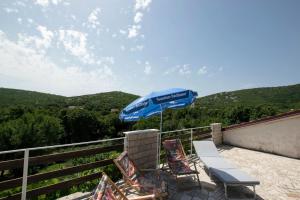 a patio with two chairs and an umbrella at Apartments Frkovic in Ledenice