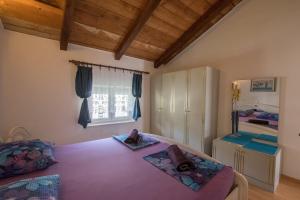 a bedroom with a purple bed and a window at Apartments Frkovic in Ledenice +71 photos
