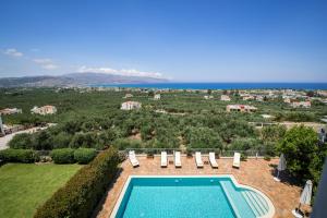 una vista aérea de la piscina y del océano en Caneva Luxury Villa, en Tavronitis