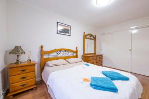 a bedroom with a bed with two blue towels on it at Rent Melbourne in Melbourne