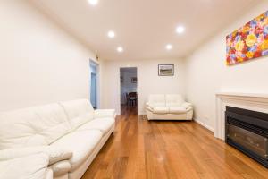 a living room with a white couch and a fireplace at Rent Melbourne in Melbourne