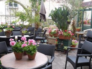 a patio with tables and chairs with flowers and plants at La Croix Blanche in Montrichard