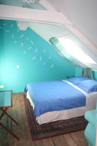 a bedroom with a bed with birds flying above it at Ar Litorienn in Paimpont