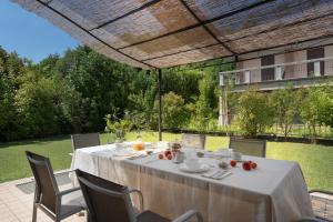 un tavolo con una tovaglia bianca su un patio di Corte Dei Cipressi apartments a Roe