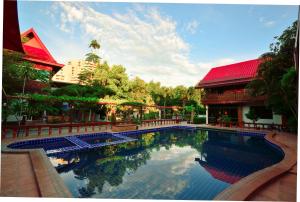 a swimming pool in front of a building at Avila Resort Pattaya in Jomtien Beach