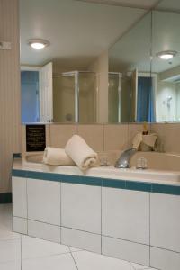 ein Bad mit einem Waschbecken und einem Spiegel in der Unterkunft Winnapaug Inn in Westerly