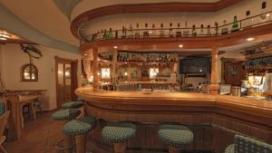eine Bar in einem Restaurant mit grünen Stühlen in der Unterkunft Alpenhotel Kronprinz in Berchtesgaden