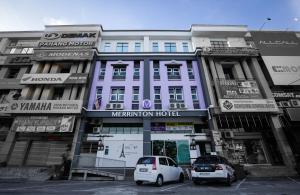 un coche blanco estacionado frente a un edificio en Merrinton Hotel Temerloh en Temerloh