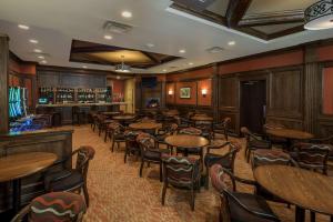 a restaurant with tables and chairs and a bar at Best Western Plus Winnipeg Airport Hotel in Winnipeg