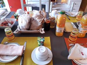 einen Tisch mit Teller und Flaschen Orangensaft in der Unterkunft Chez Marie in Cercy-la-Tour