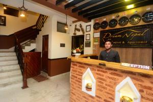 a man standing behind a bar in a restaurant at Dream Nepal Hotel and Apartment in Kathmandu
