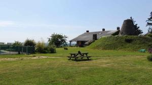 a picnic table in a field next to a house at Moulin de la Placette in Faye-dʼAnjou +12 photos