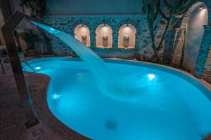 eine Whirlpool-Badewanne in einem Zimmer mit blauer Beleuchtung in der Unterkunft Thalassa Boutique Hotel in Rethymno