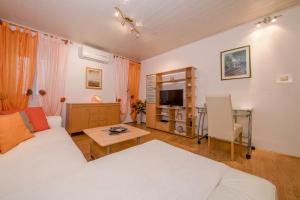 a living room with a white couch and a table at Apartment Patricia in Rab