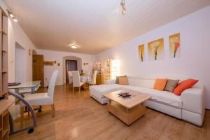 a living room with a white couch and a table at Apartment Patricia in Rab