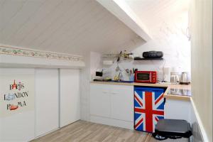 ベジエにあるBeziers Studio Terrasseの白いキャビネットと赤い電子レンジ付きのキッチンが備わります。