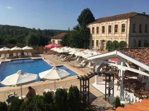 a large pool with white umbrellas and a building at Hotel Bukor Shtepi Magnolia in Mandrica