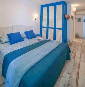 un letto blu con cuscini blu in una camera da letto di Faro di Capo Testa a Bonifacio