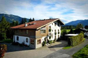 una casa grande con techo rojo en Pension Erlhof, en Saalfelden am Steinernen Meer