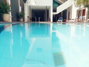 a blue swimming pool with chairs in a building at Sea Port in Negombo
