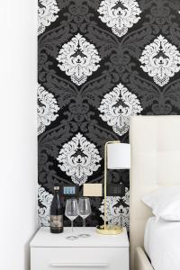 a bedroom with a black and white damask wallpaper at Lake Como Golf Hotel in Como