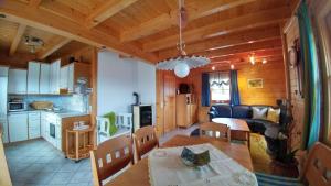 a kitchen and a living room with a table and a dining room at Almchalet Orter in Deutschberg