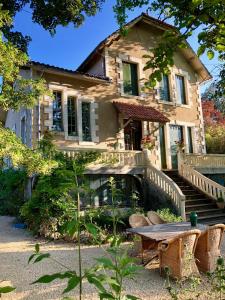 a house with a table and chairs in front of it at Villa Léovil in Saint-Pompont