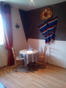 a table with two chairs and a clock on the wall at L'étape Marceline - Chambre D'hôtes in Saint-Marceau +21 photos