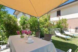 un tavolo con una tovaglia bianca e un ombrello giallo di Corte Dei Cipressi apartments a Roe