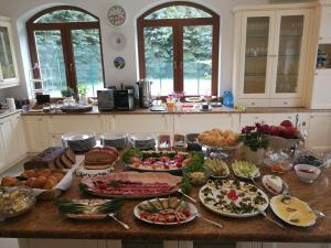 una mesa con muchos platos de comida. en Rezydencja Rodzinna, en Augustów