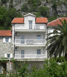 duży kamienny budynek z balkonem w obiekcie Apartments Villa Lipci w mieście Donji Morinj