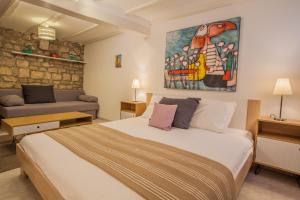 a bedroom with a bed and a painting on the wall at Honey Art Apartment in Cres
