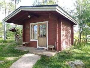 a smallshed with two benches in front of it at Pirttiniemen Lomakylä in Muurasjärvi